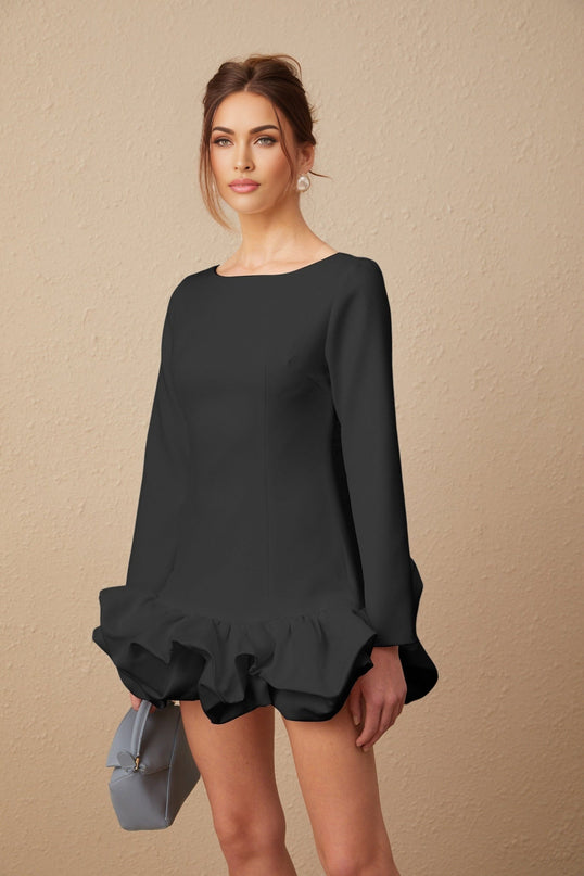 A black mini dress with a bubble skirt and fitted bodice worn by a model standing against a plain background