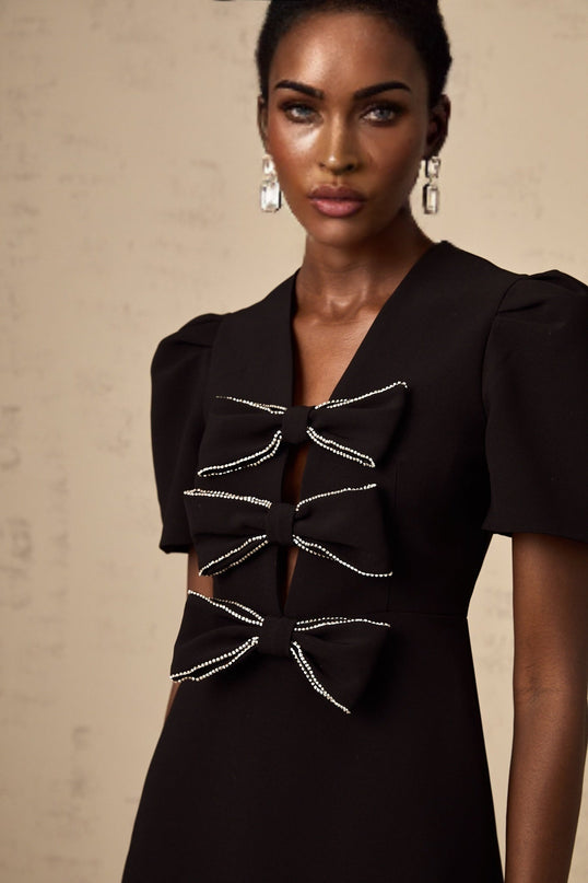 A black mini dress with a decorative bowknot detail