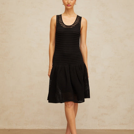 A black mini dress with a flounced hem and pointelle knit pattern featuring short sleeves and a fitted silhouette