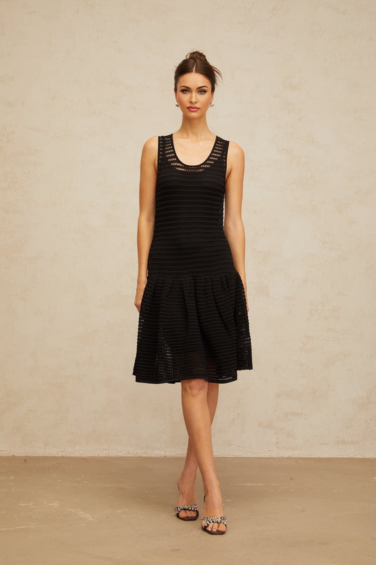 A black mini dress with a flounced hem and pointelle knit pattern featuring short sleeves and a fitted silhouette