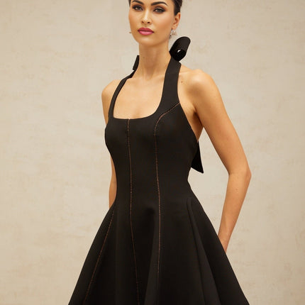 A black mini dress with a halterneck design featuring a bow detail at the neckline