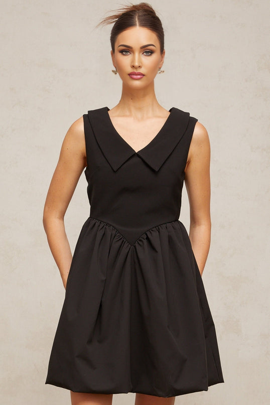 A black mini dress with a lapel collar and puff sleeves featuring a fitted silhouette and short length