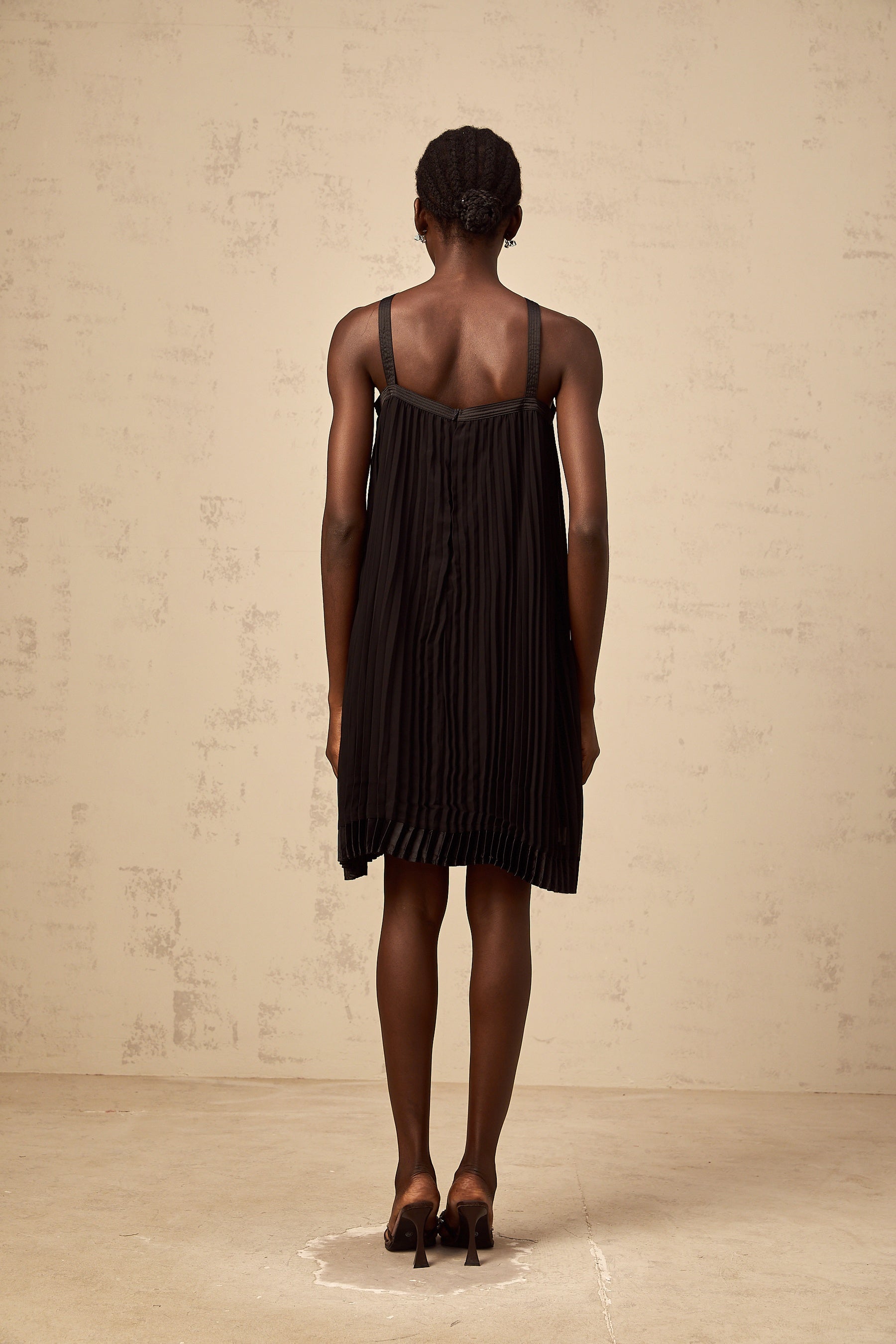 A black mini dress with a pleated skirt and a large bow detail at the waist inspired by the Zelda video game series