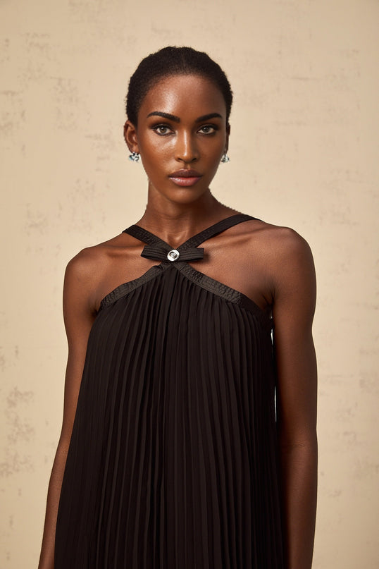 A black mini dress with a pleated skirt and a large bowknot detail inspired by Zelda style