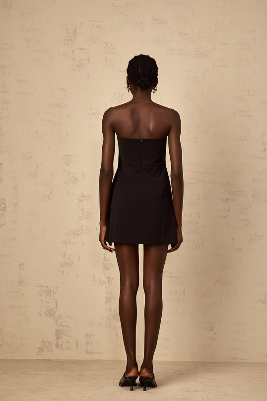 A black mini dress with an offshoulder neckline featuring sequin floral embroidery worn by a woman