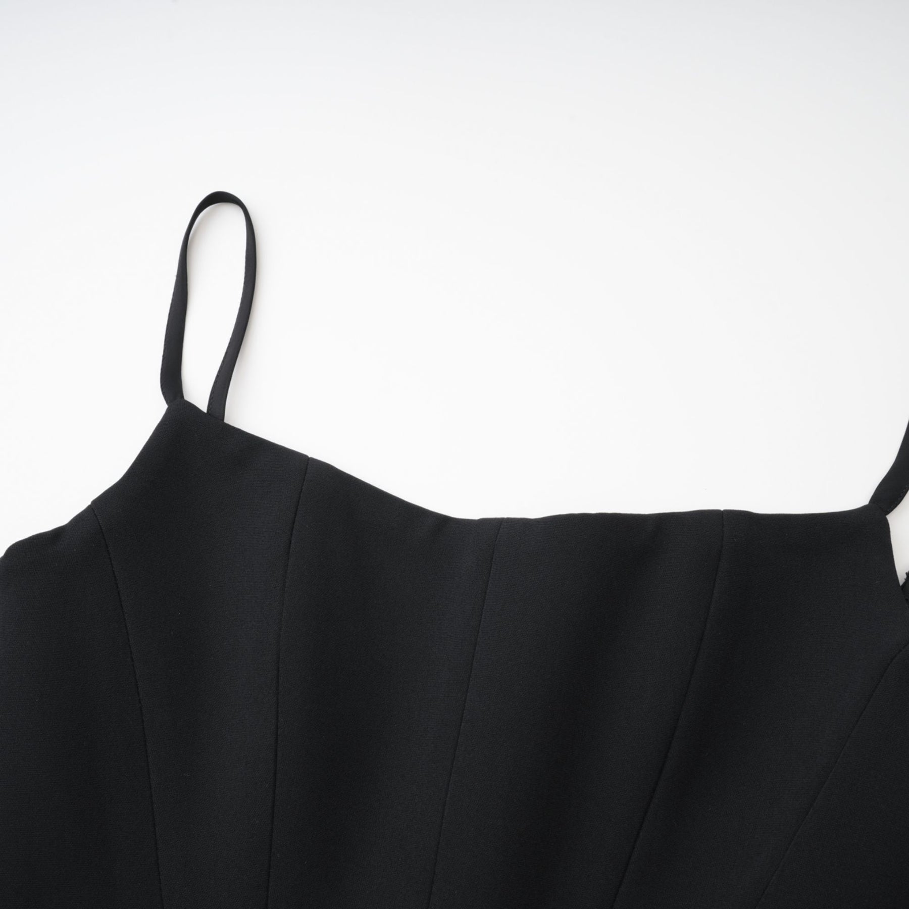 A black sleeveless dress with spaghetti straps square neck and a draped design Rear zip fastening and mini length 80% Polyester 20% Cotton