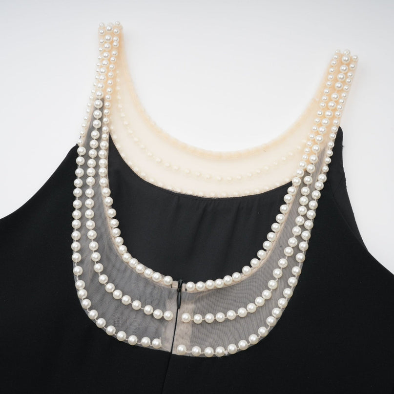 A black mini dress with faux pearl embellishments called Danae