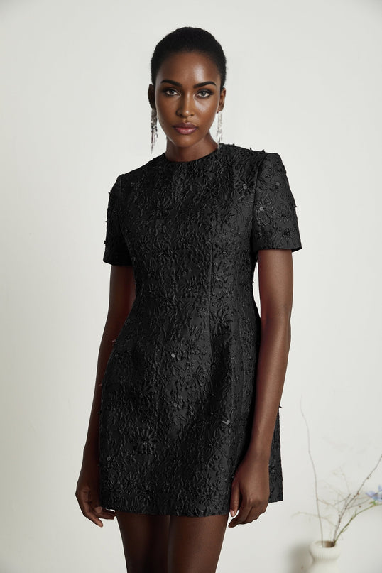 A black mini dress with floral applique and embellishments called Celestia