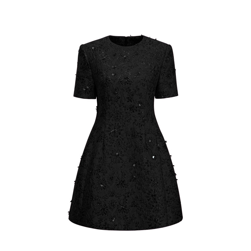 A black mini dress with floral applique embellishments and a celestial inspired design