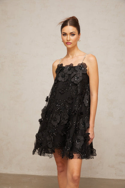 A black mini dress with floral pattern and crystal embellishments called Suzette featuring a short length and feminine design