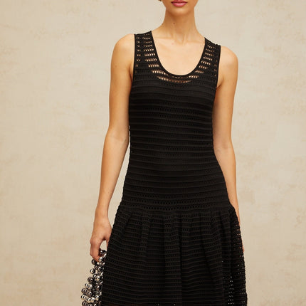 A black mini dress with flounced details and pointelle knit fabric featuring a short hemline and textured pattern