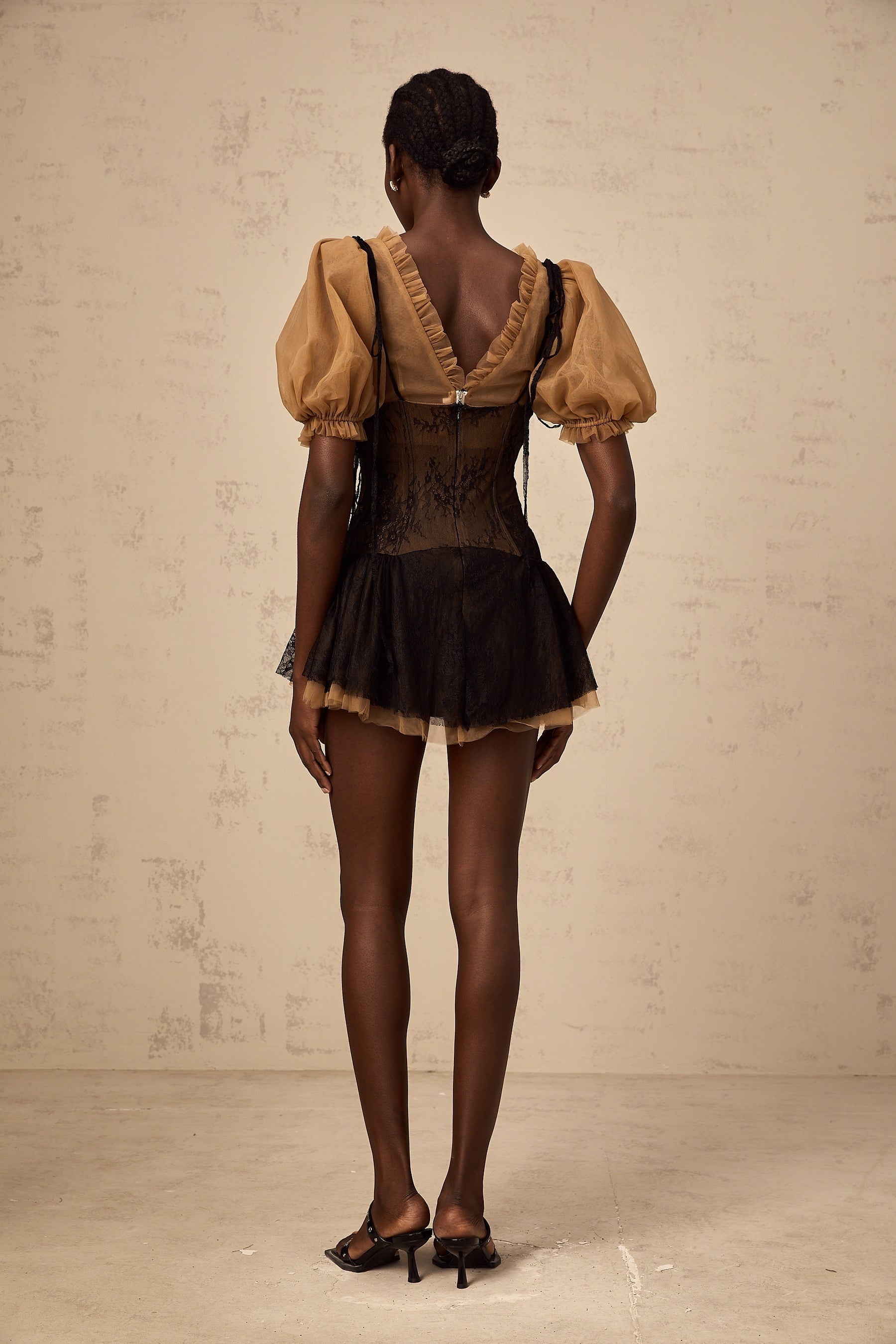 A black mini dress with lace panelling details and a fitted silhouette