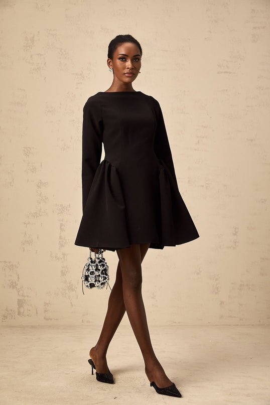 A black mini dress with long sleeves and a flared skirt on a white background