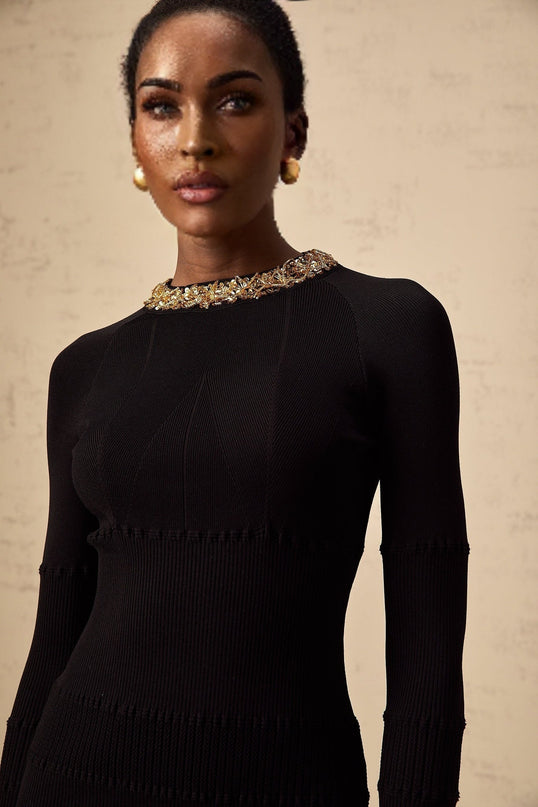 A black mini dress with ribbed knit fabric covered in shiny sequins