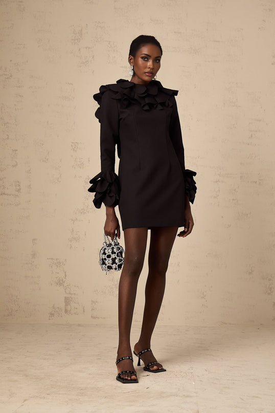 A black mini dress with ruffled details and an open back design called Jacques