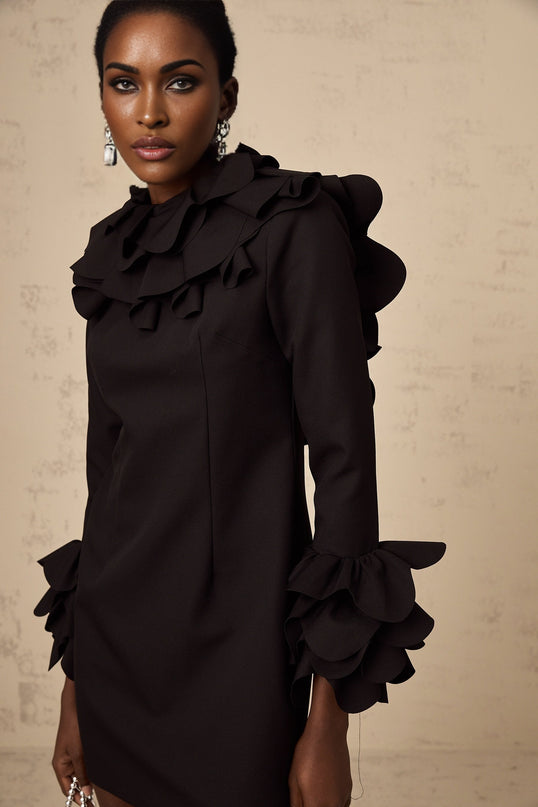 A black mini dress with ruffled details and an open back design called Jacques