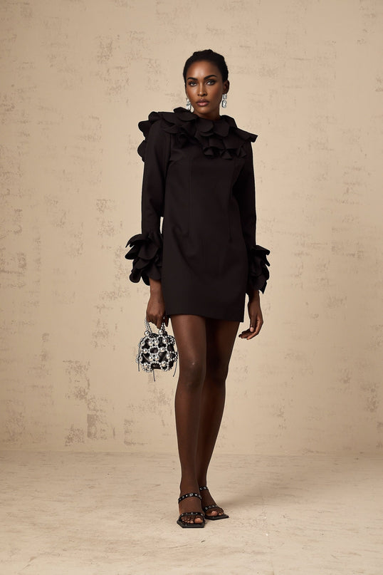 A black mini dress with ruffled details and an open back design named Jacques