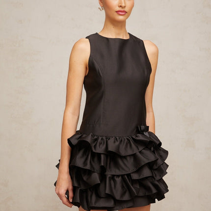 A black mini dress with ruffled tiers and a short hemline featuring a feminine and playful design