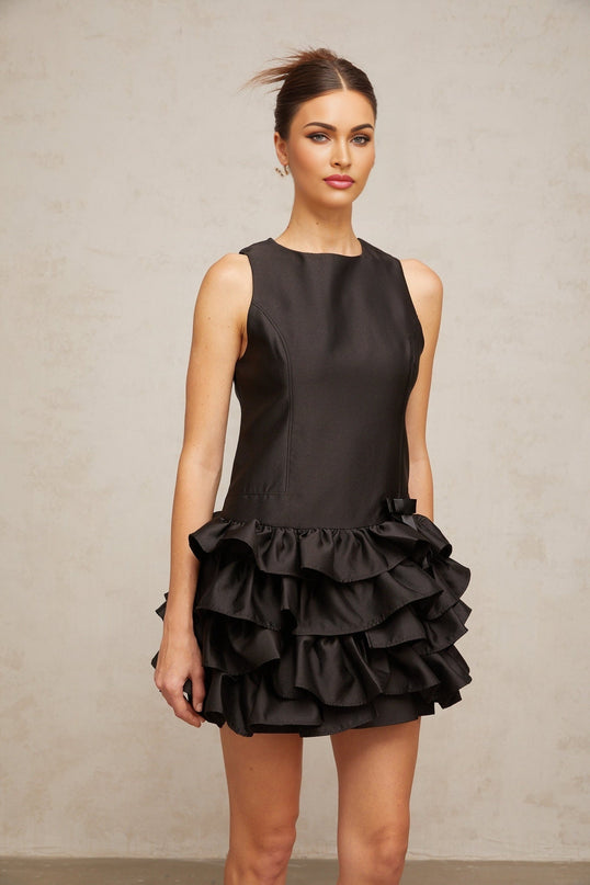 A black mini dress with ruffled tiers and a short hemline featuring a feminine and playful design
