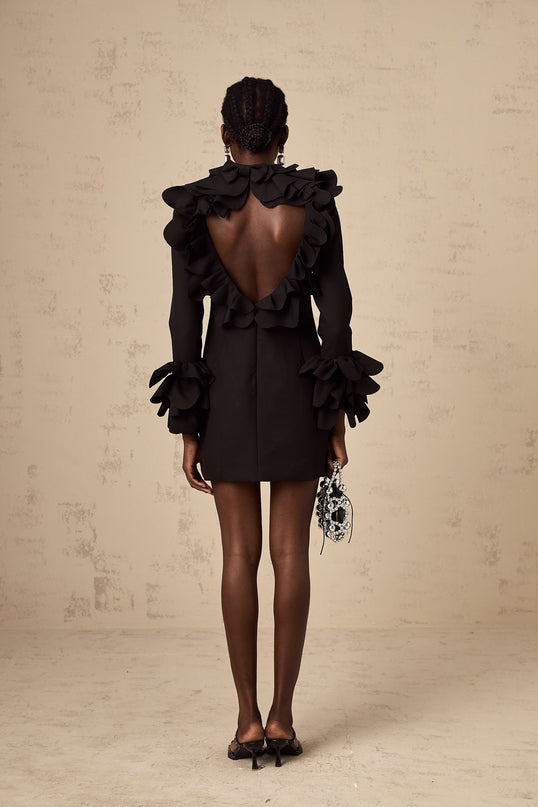 A black mini dress with ruffles and an open back design called the Jacques dress