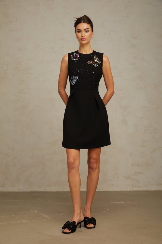 A black mini dress with sequined butterfly design featuring a short hemline and shimmering embellishments