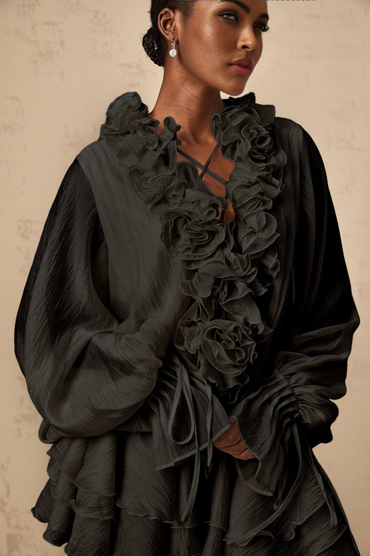 A black mini dress with tiered skirt and floral appliques called Zephyrine