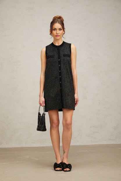 A black mini dress with vertical stripes and sequin embellishments featuring a knit fabric and short hemline inspired by Zelda style
