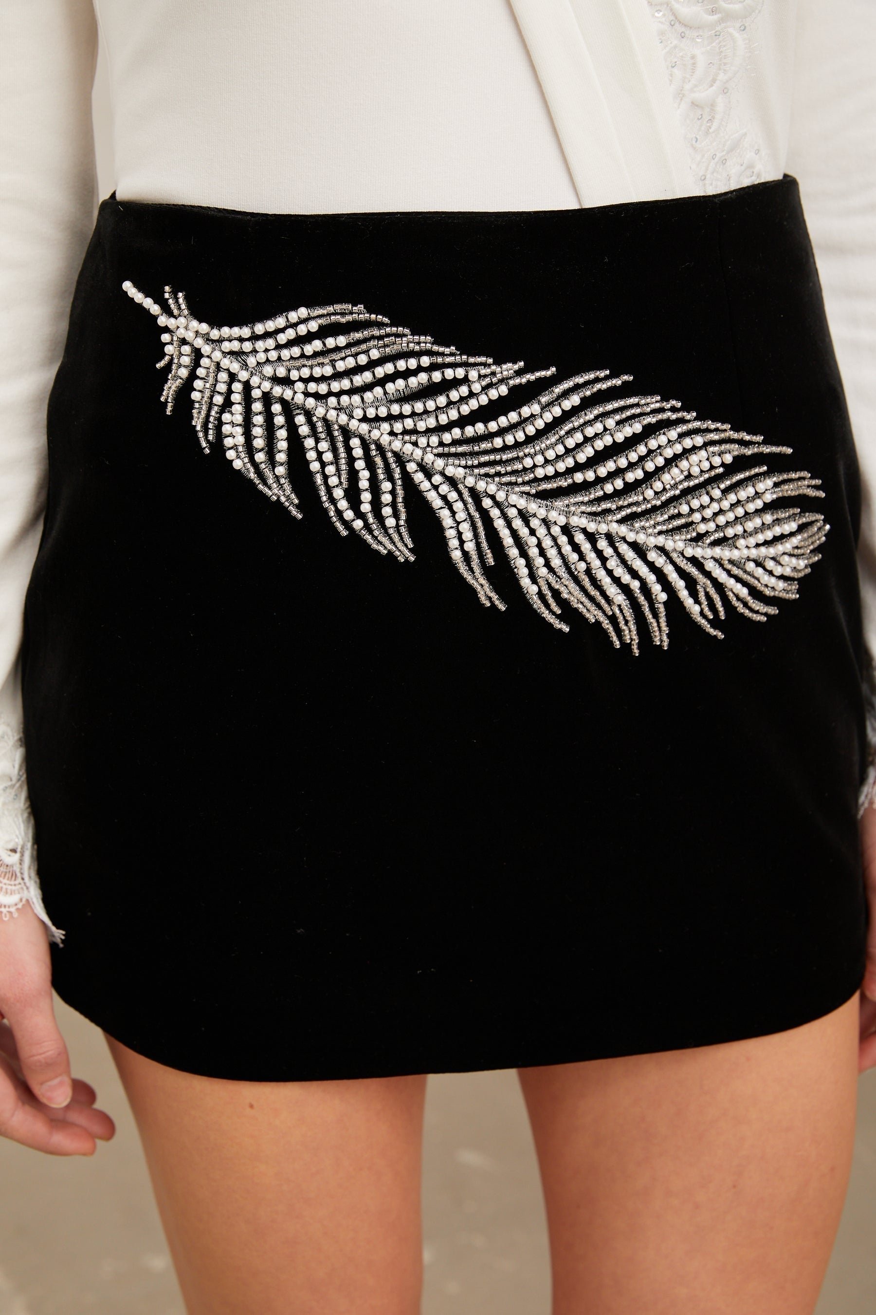 A black mini skirt with embellished feather embroidery details named Myriam