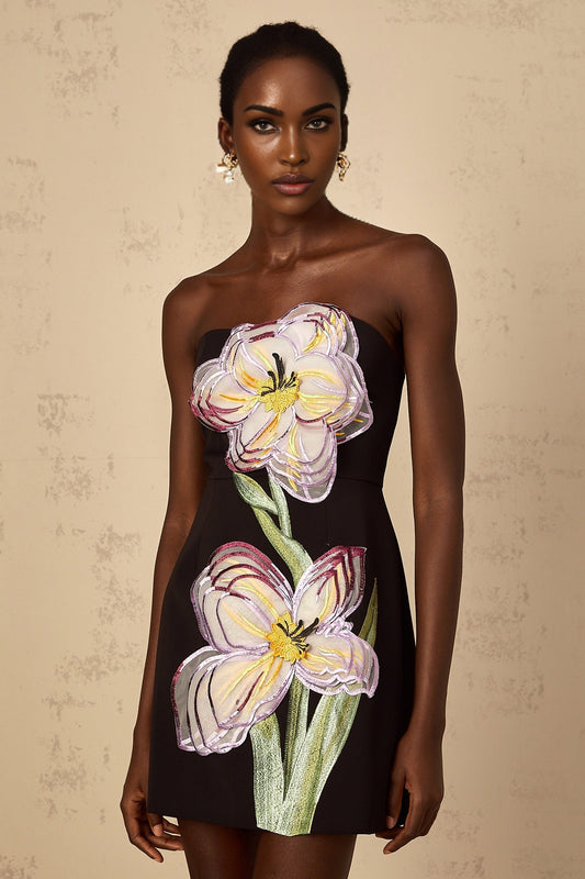 A black off shoulder mini dress with sequin and floral embroidery details worn by a woman named Irene