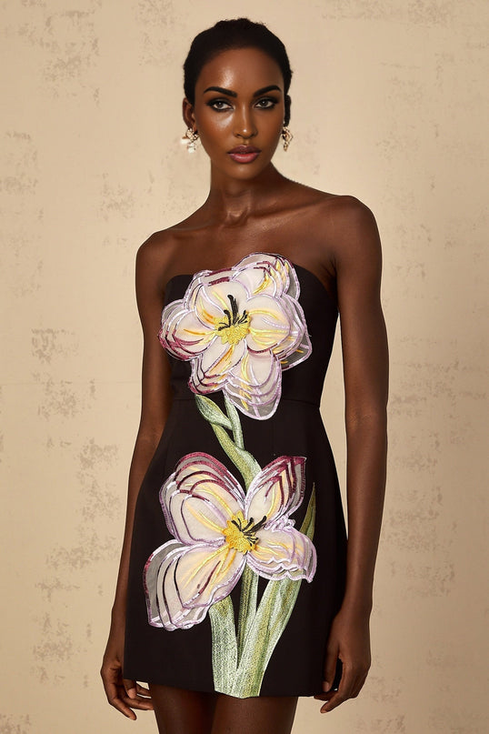 A black off shoulder mini dress with sequin and floral embroidery details worn by a woman named Irene