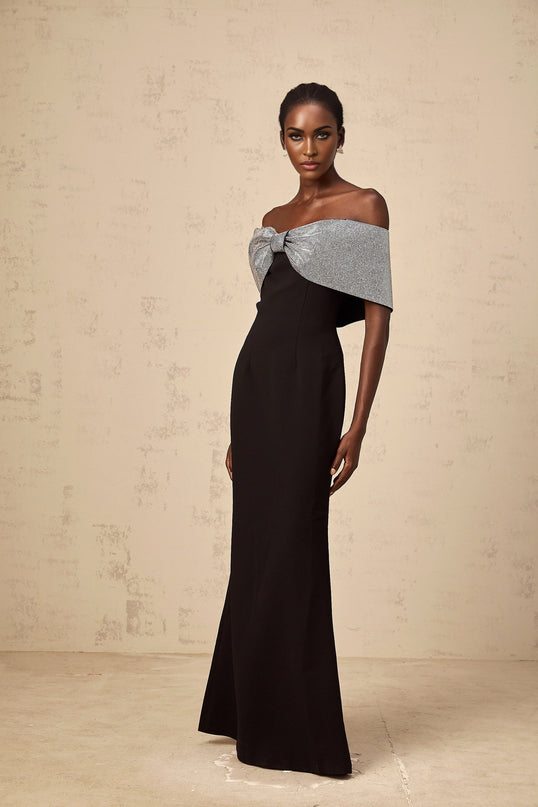 A black offshoulder maxi dress by Chloé featuring a rhinestone bow embellishment