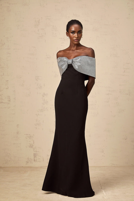 A black offshoulder maxi dress with a rhinestone bow detail designed by Chloé