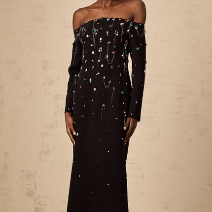 A black offshoulder maxi dress with crystal embellishments named Gabrielle featuring a long flowing skirt and elegant silhouette