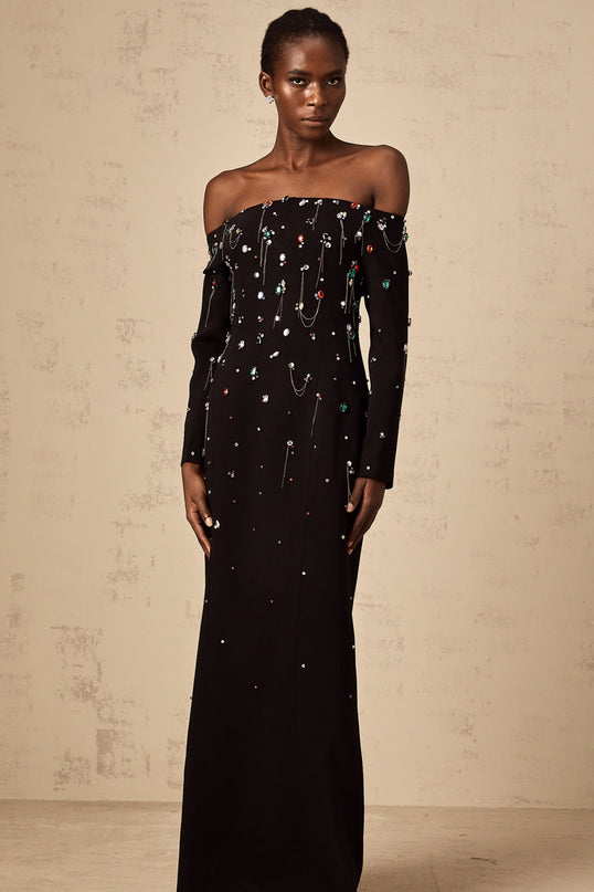 A black offshoulder maxi dress with crystal embellishments named Gabrielle featuring a long flowing skirt and elegant silhouette