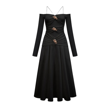A black offshoulder maxi dress with panelled design featuring a long flowing skirt and fitted bodice worn by a model