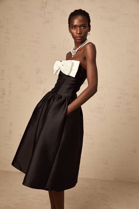 A black offshoulder midi dress made of georgette fabric featuring a bow detail at the neckline