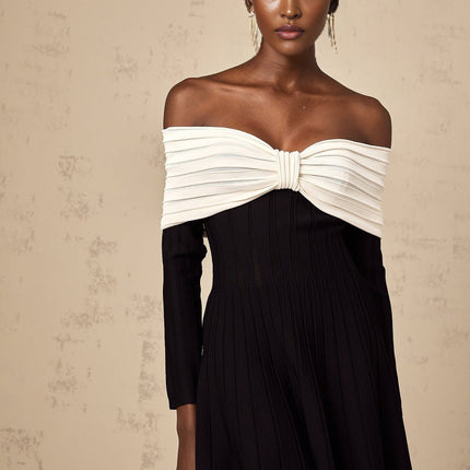 A black offshoulder mini dress with a bow detail and knit fabric featuring a figurehugging silhouette and short length