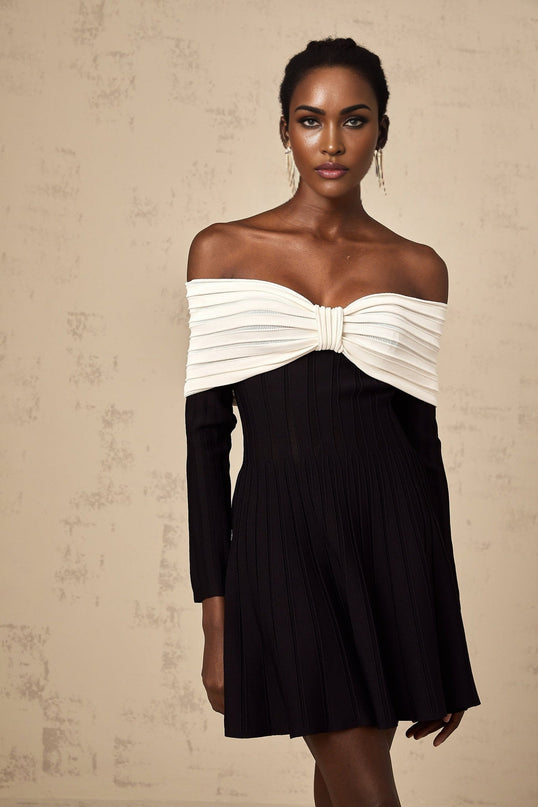 A black offshoulder mini dress with a bow detail and knit fabric featuring a figurehugging silhouette and short length