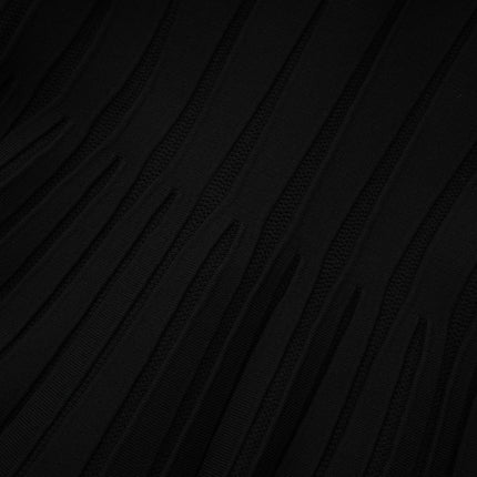 A black offshoulder mini dress with a bow detail and knit fabric worn by a model against a plain background