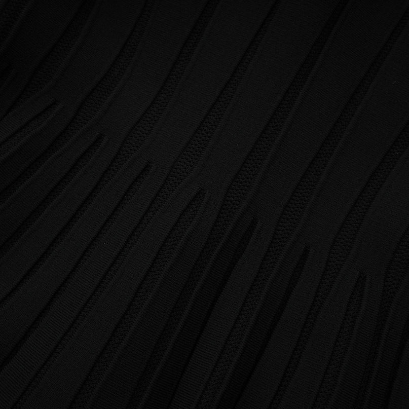 A black offshoulder mini dress with a bow detail and knit fabric worn by a model against a plain background