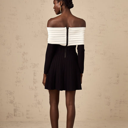 A black offshoulder mini dress with a bow detail and knit fabric worn by a model