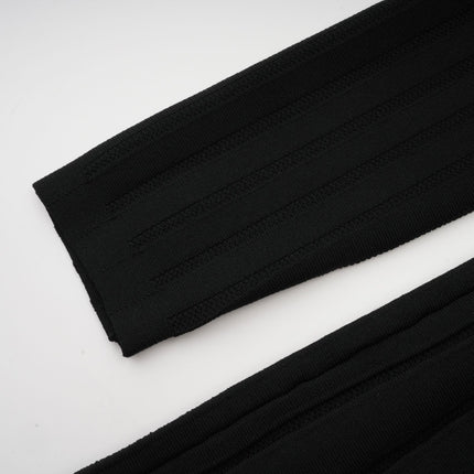 A black offshoulder mini dress with a bow detail and knit fabric worn by a model