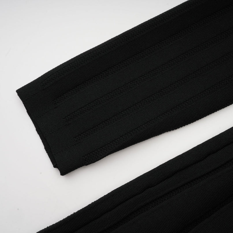 A black offshoulder mini dress with a bow detail and knit fabric worn by a model