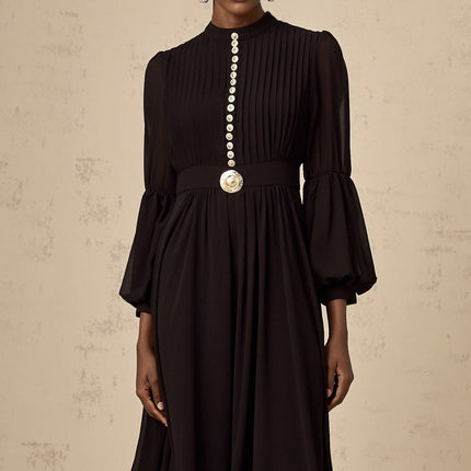 A black pleated midi dress with a button front closure and the name Viviane