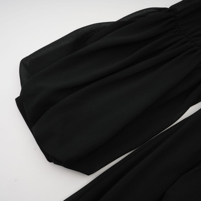 A black pleated midi dress with a buttonfront design featuring long sleeves and a fitted waist