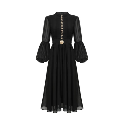 A black pleated midi dress with a buttonfront design featuring long sleeves and a flowing silhouette