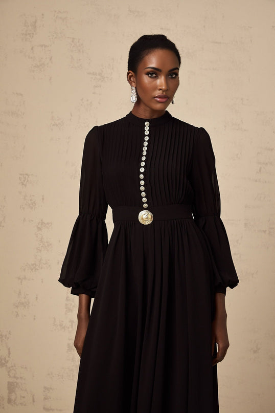 A black pleated midi dress with a buttonfront design featuring long sleeves and a flowy silhouette