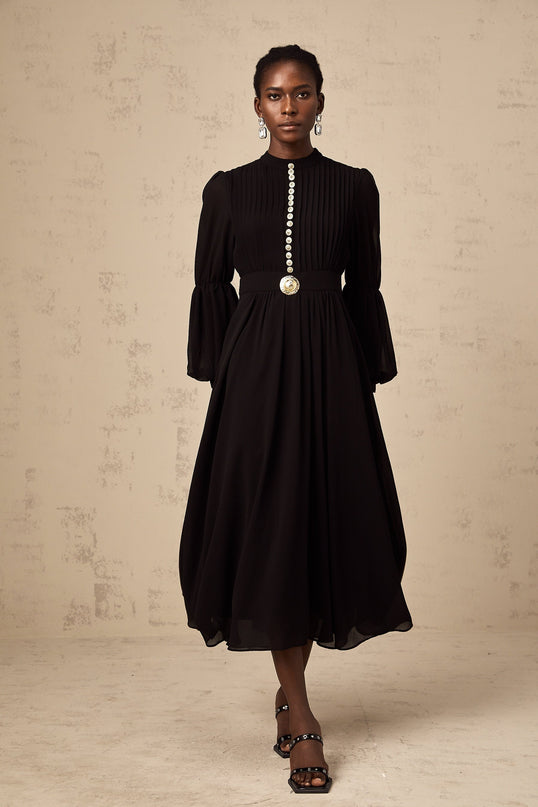 A black pleated midi dress with buttonfront closure featuring long sleeves and a fitted silhouette named Viviane
