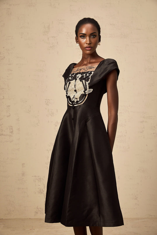 A black satin midi dress with floral applique detailing named Ulrique