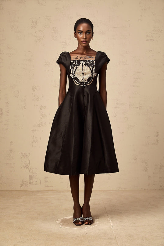A black satin midi dress with floral applique detailing on Ulrique design